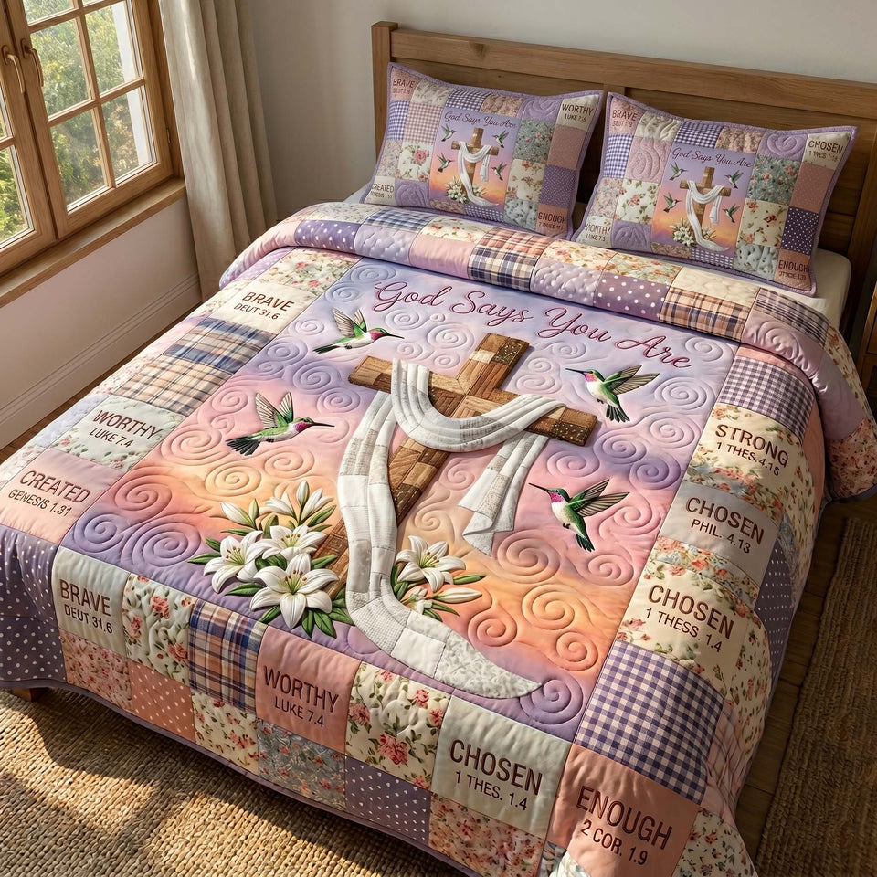 Cross and Lily Dawn quilted bedding set, quilt and two pillow shams on a made bed