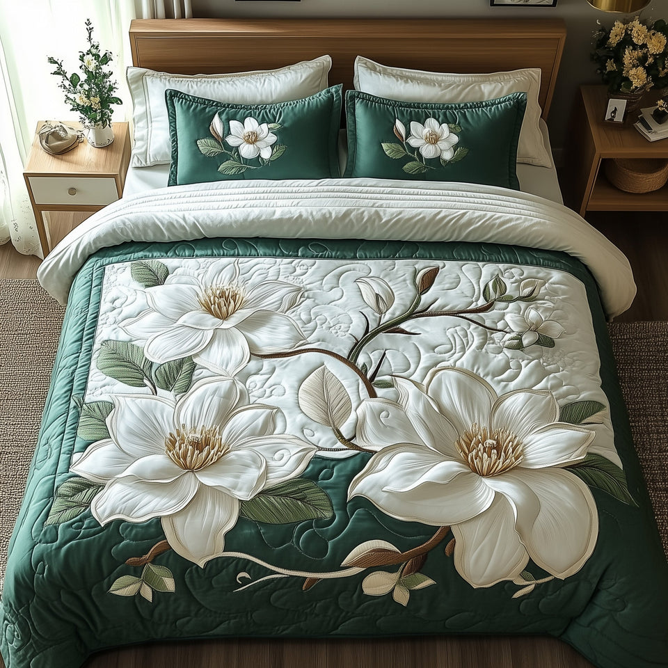 Elegant Magnolia Emerald Bloom quilted bedding set, quilt and two pillow shams on a made bed