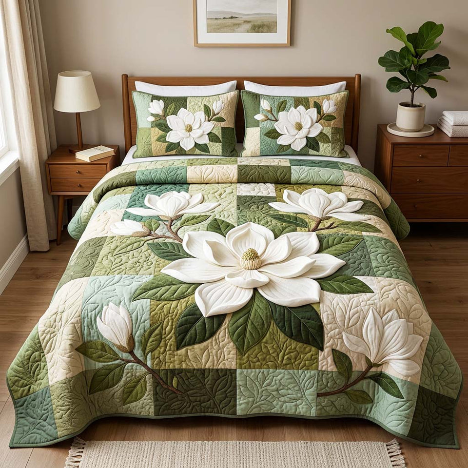 Elegant Magnolia quilted bedding set, quilt and two pillow shams on a made bed