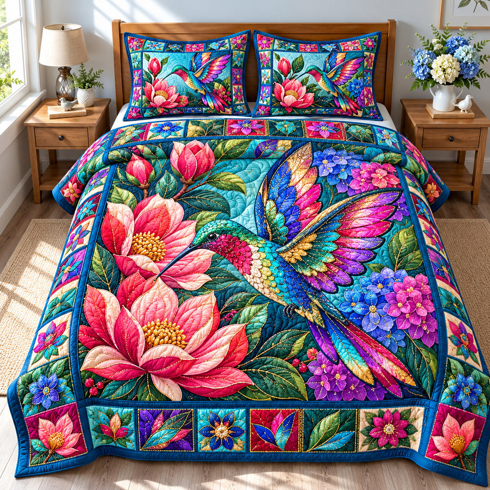 Hummingbird Floral Glow quilted bedding set, quilt and two pillow shams on a made bed
