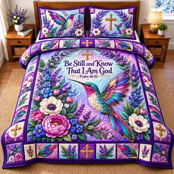 Hummingbird Floral Haven quilted bedding set, quilt and two pillow shams on a made bed