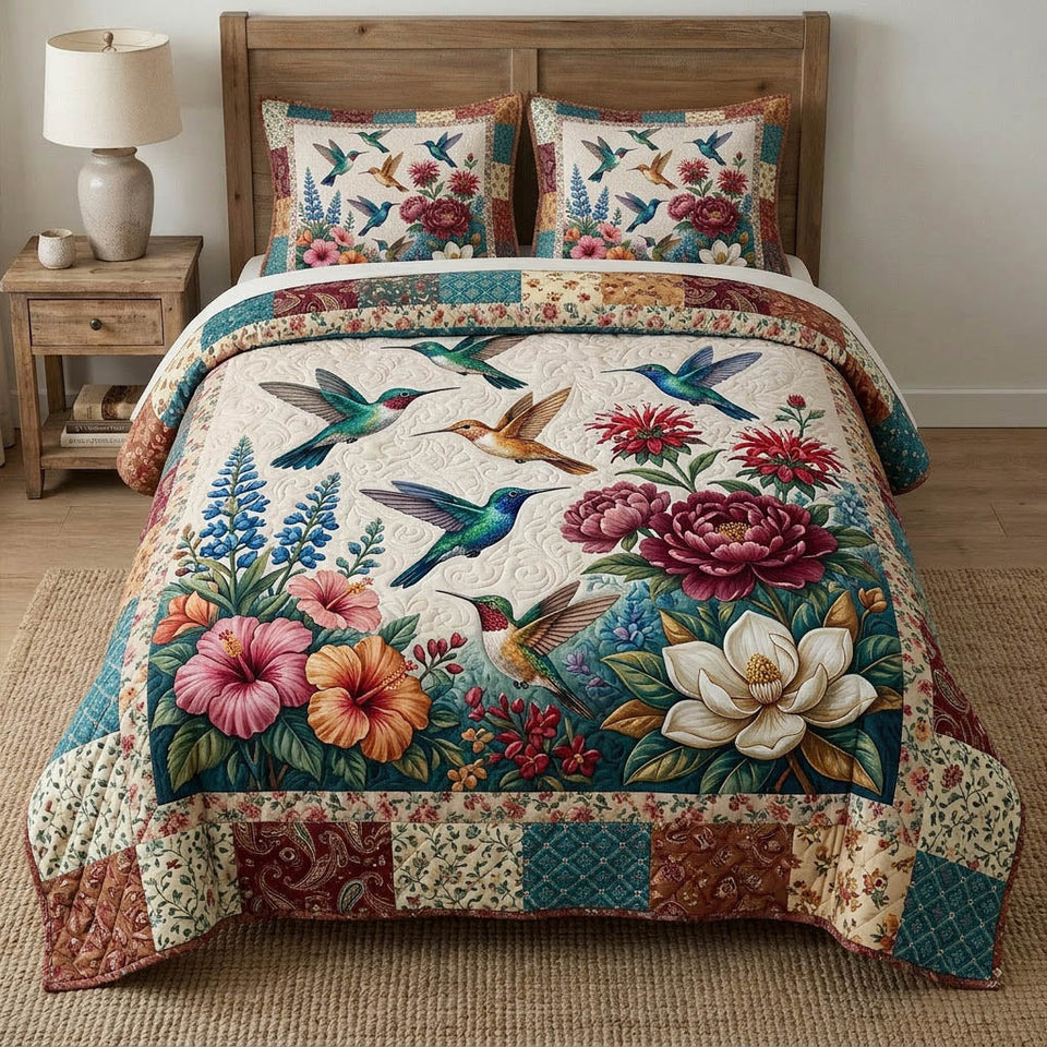 Hummingbird Grove Blossoms quilted bedding set, quilt and two pillow shams on a made bed