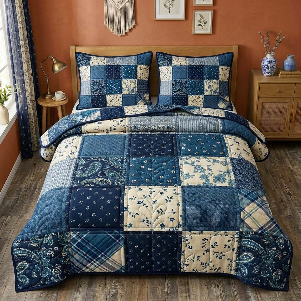 Indigo Patchwork quilted bedding set, quilt and two pillow shams on a made bed