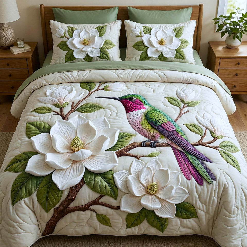 Iridescent Drift Magnolia Branch quilted bedding set, quilt and two pillow shams on a made bed