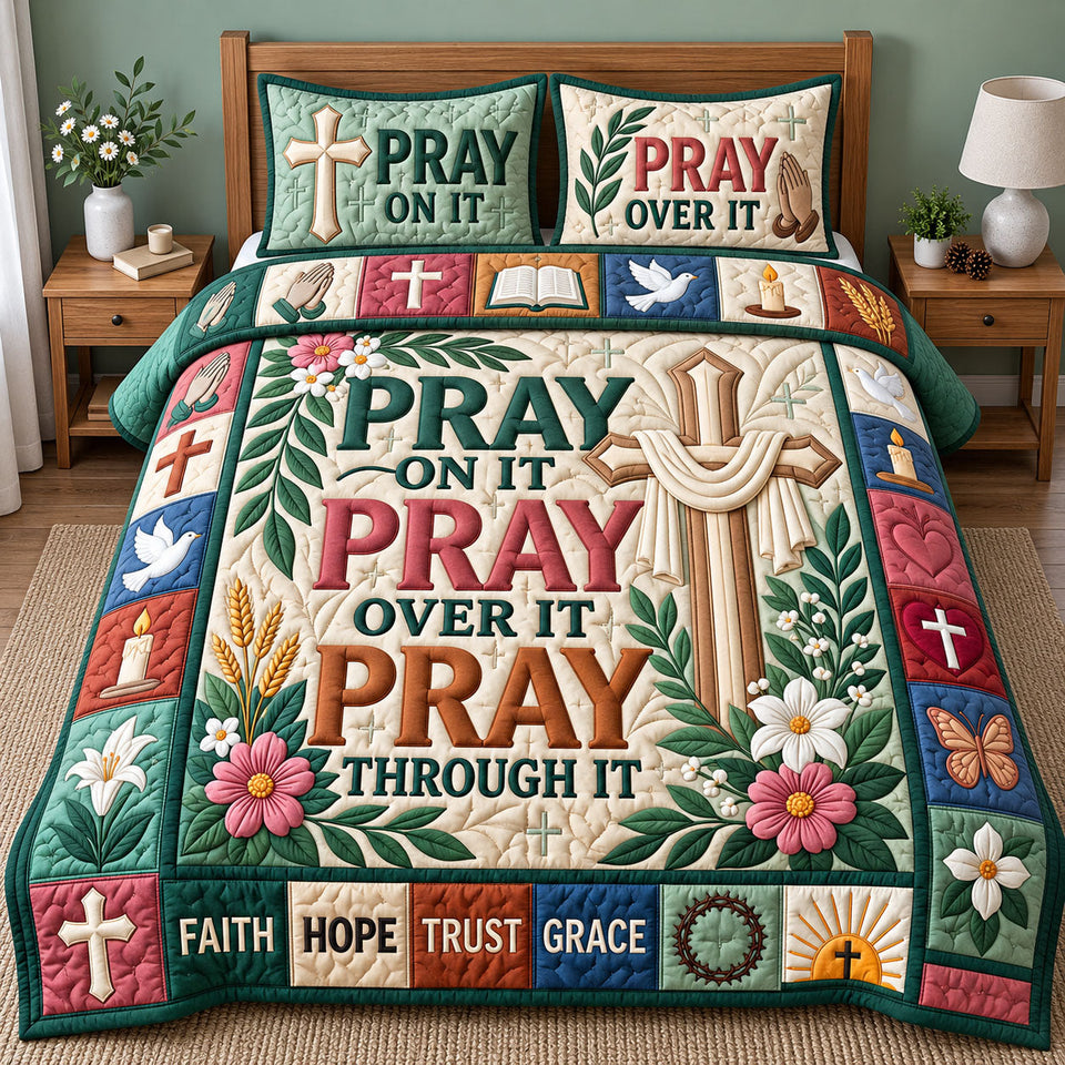 Pray On It quilted bedding set, quilt and two pillow shams on a made bed