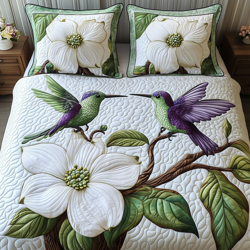 Spring Hummingbird quilted bedding set, quilt and two pillow shams on a made bed